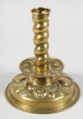 A GOOD EARLY FLEMISH BRASS REPOUSSE CANDLESTICK on a circular base. 8ins high.