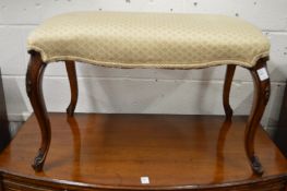 A good upholstered footstool of serpentine outline on carved walnut cabriole legs.