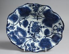 A BOW OVAL DISH moulded with grape leaves and painted in underglaze blue with grapes and vine.