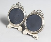 A PAIR OF SILVER CIRCULAR PHOTOGRAPH FRAMES, with pierced cresting on shaped feet. 2.5ins wide x 3.