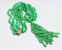 A LONG STRING OF JADE BEADS with 18ct and diamond clasp.