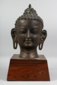 A LARGE BRONZE BUDDHA HEAD on stand. 23ins high.