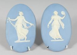 A PAIR OF WEDGWOOD JASPER WARE OVAL PLAQUES, classical female dancers. 5.5ins x 3.5ins.