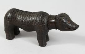 A FOLK ART LIGNUM VITAE CARVED PIG. 7.5ins long.