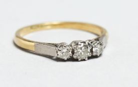 AN 18CT GOLD THREE STONE DIAMOND RING.