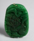 A LARGE CHINESE CARVED GREEN JADE PENDANT. 2.25ins