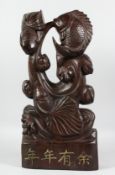 A LARGE CHINESE CARVED WOOD FISH FIGURE with calligraphy. 22ins long.