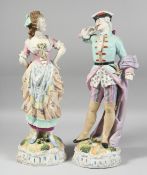 A GOOD PAIR OF CONTINENTAL FIGURES OF A YOUNG GALLANT AND A YOUNG GIRL on encrusted bases. 17ins