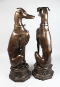 A LARGE PAIR OF BRONZE SEATED DOGS on an octagonal base. 30ins high.