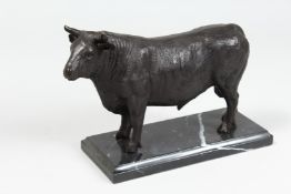 A BRONZE BULL on a marble base. 9ins long.