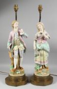 A LARGE PAIR OF CONTINENTAL FIGURES OF A YOUNG GALLANT AND A YOUNG GIRL fitted as lamps with gilt
