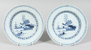 A PAIR OF 19TH CENTURY TIN GLAZE PLATES with buildings, trees, etc.. 9ins diameter.
