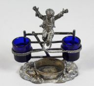 A VICTORIAN METAL DOUBLE SALT, a young boy jumping a style.