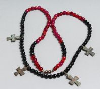 A RED AND BLACK NECKLACE with four small Roman crosses.