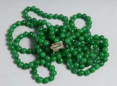 A SUPERB JADE TRIPLE ROW NECKLACE with gold and diamond clasp.