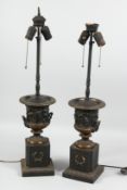 A GOOD PAIR OF BRONZE TWO HANDLED URN LAMPS on pedestal bases.