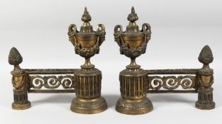 A GOOD PAIR OF LOUIS XVI GILT BRONZE CHENETS with urn finials, masks and pineapple finials. 12ins