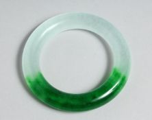 A TWO TONE JADE BANGLE. 3.25ins diameter.