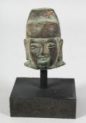 A CHINESE BRONZE HEAD SECTION raised on a wooden stand, the head measuring 6.5cm high