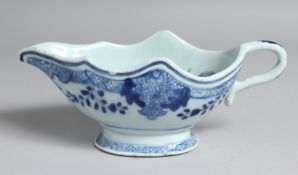 A CHINESE BLUE AND WHITE PORCELAIN SAUCE BOAT, the interior decorated with native flora. 21cm long