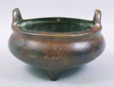 A CHINESE BRONZE TWIN HANDLE TRIPOD CENSER, with four character mark to base, 15cm diameter.