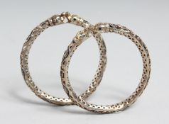 A PAIR OF INDIAN ENAMELLED SILVER OPENWORK BANGLES with Makkara heads, 7.5cm diameter.