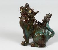 A GOOD CHINESE BROWN AND TURQUOISE GLAZE POTTERY TEMPLE LION, 18cm high.