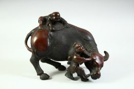 A CHINESE BRONZE MODEL OF AN OXEN, with two young boys upon it, 16.5cm long.