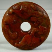 A SMALL CHINESE CARVED HARDSTONE DISK, carved with chilong motif, 6cm diameter.