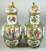 A PAIR OF CHINESE CANTON FAMILLE ROSE PORCELAIN VASES AND COVERS, painted with panels of figures