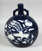 A CHINESE SACRIFICIAL BLUE GROUND TWIN-HANDLED MOON FLASK, decorated with white phoenix amongst