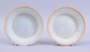 A PAIR OF CHINESE CELADON GLAZED POTTERY BOWLS, the interior decorated with incised underglaze