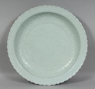 A GOOD LARGE CHINESE CELADON GLAZE PORCELAIN CHARGER, with incised foliate decoration, moulded petal
