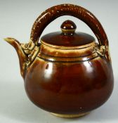 A CHINESE BROWN GLAZE POTTERY TEAPOT AND COVER, the handle moulded as a chilong dragon, 13.5cm