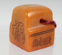 A CHINESE HARDSTONE SEAL with carved characters to the sides. 4cm high