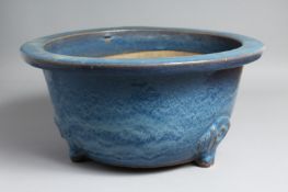 A LARGE CHINESE BLUE-GLAZED PLANTER, slightly raised on three moulded feet. 39.5cm diameter