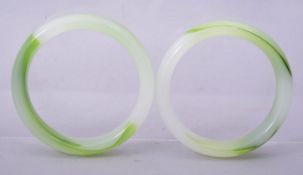 A PAIR OF CHINESE GREEN GLASS BANGLES, 8.5cm diameter.