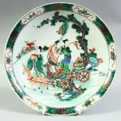 A CHINESE FAMILLE VERTE PORCELAIN DISH, painted with figures and deer beside a tree, the base with