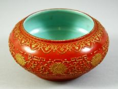 A CHINESE RED GROUND PORCELAIN BOWL, with raised gilt decoration, the interior and base with