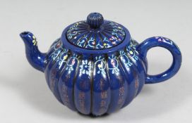 A CHINESE SACRIFICIAL BLUE GLAZED YIXING TEAPOT, the ribbed body with gilt characters, the base with