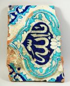 AN ISLAMIC GLAZED POTTERY TILE PANEL with Qur'anic script to the centre. 26.5cm x 20cm