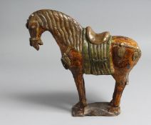 A CHINESE GREEN AND YELLOW GLAZED POTTERY MODEL OF A HORSE. 24.5cm long