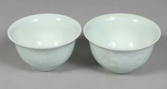 A PAIR OF CHINESE CELADON GLAZE PORCELAIN TEA CUPS, with carved floral decoration to the