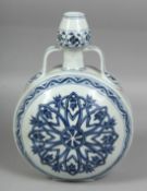 A CHINESE BLUE AND WHITE PORCELAIN TWIN HANDLE MOON FLASK, the central decorative motif with yin
