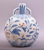 A CHINESE MING STYLE BLUE AND WHITE AND UNDER GLAZED RED TWIN HANDLE MOONFLASK VASE, decorated
