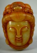 A CHINESE CARVED JADE / HARDSTONE AMULET of a Buhhistic head, the reverse with very fine