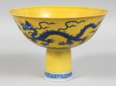 A CHINESE IMPERIAL YELLOW GROUND BLUE AND WHITE PORCELAIN STEM CUP, decorated with dragons and