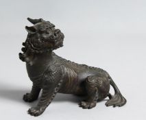 A BRONZE FIGURE OF A LION DOG, 15cm long.