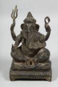 AN INDIAN BRONZE FIGURE OF GANESH, seated on a rectangular base raised on four feet, 16cm high.