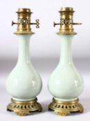 A PAIR OF CELADON PORCELAIN VASES CONVERTED TO LAMPS with brass mounts, 40cm high.